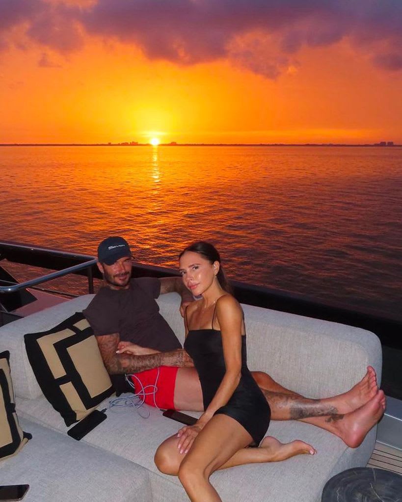 Victoria and David on a boat in front of a sunset