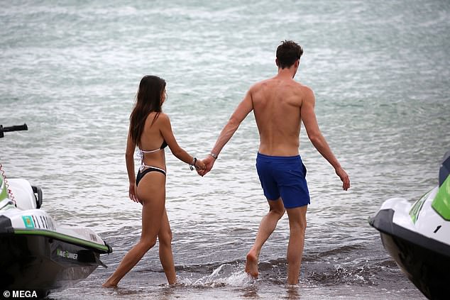 Sweet: The two were hand-in-hand as they strolled on the beach