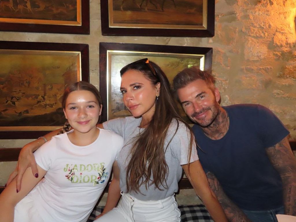 Harper Beckham wearing a 'J'adore Dior' T-shirt as she poses with Victoria and David Beckham