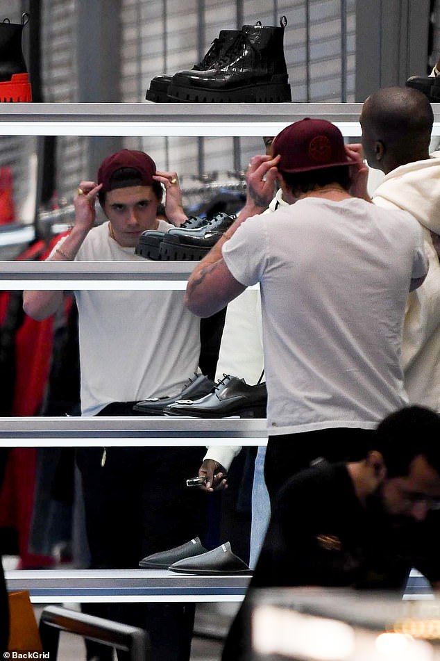 Shopping trip: Meanwhile Brooklyn visited Cartier and Balenciaga to browse the footwear and watches, checking himself out in the mirror as he adjusted his hat