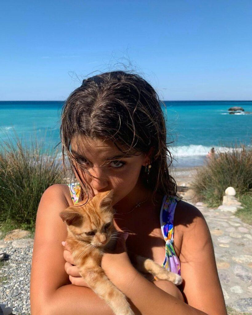 Zoe Gara kissing a kitten at the beach.