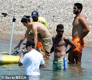 Help from the pros: Cruz climbed aboard his paddle board with a little help from the pros