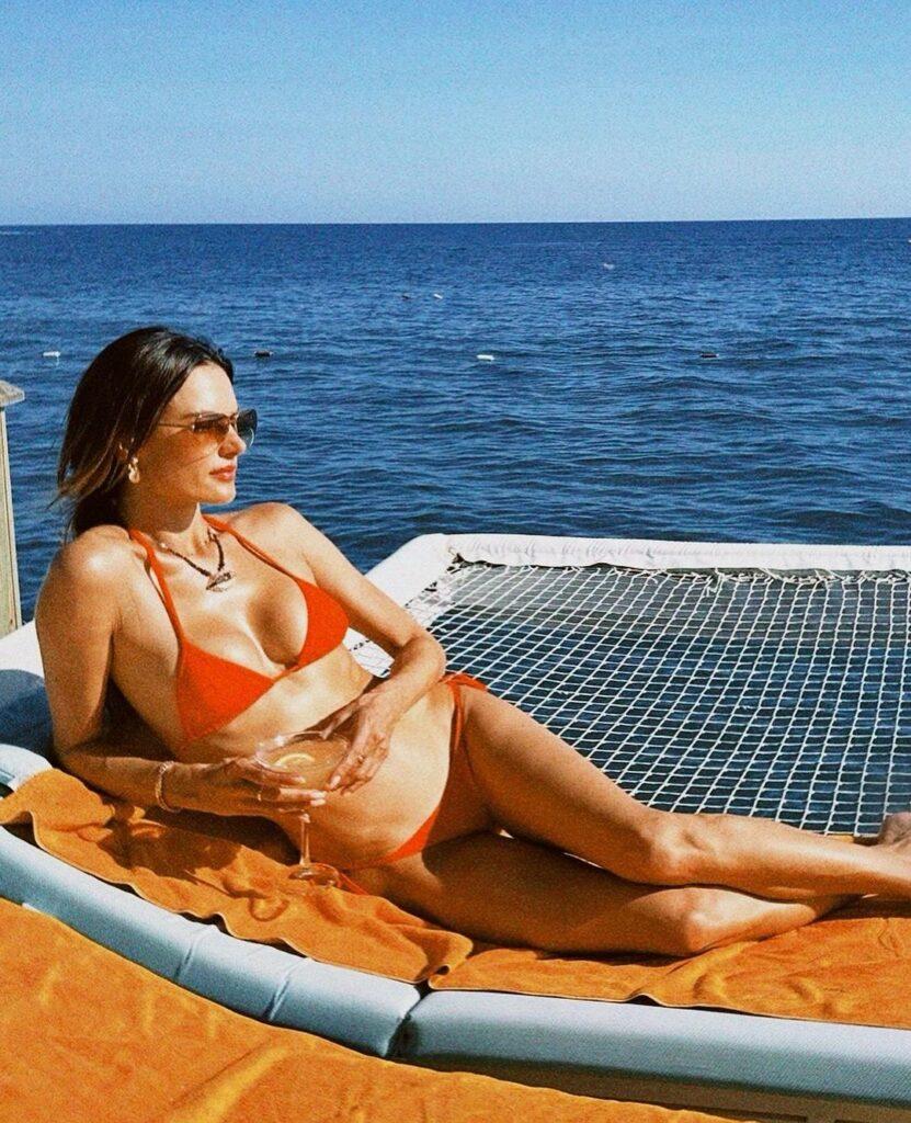 Alessandra Ambrosio basking in the sun in her orange bikini.