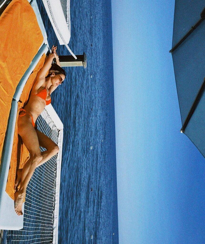 Alessandra Ambrosio basking in the sun in her orange bikini.