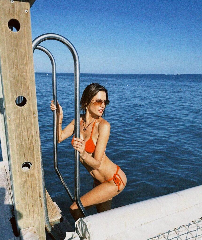 Alessandra Ambrosio basking in the sun in her orange bikini.