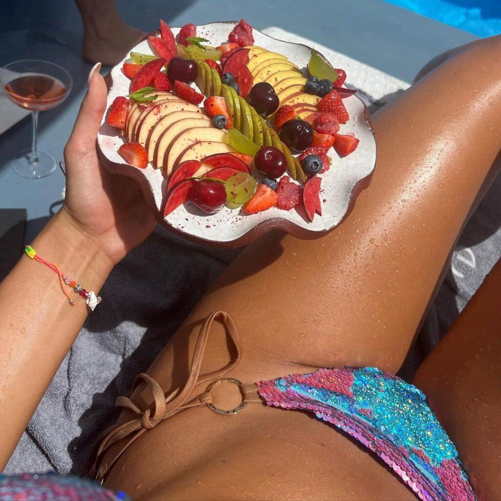 Andreea Dragoi holds a plate filled with fruits.