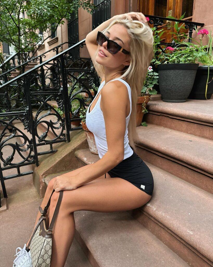 Olivia Dunne wears a tank top and shorts while sitting on the stairs in New York.