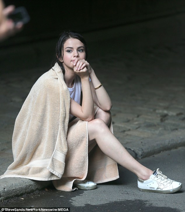 Taking no risks: Selena was given a towel after the long period of time in the rain 