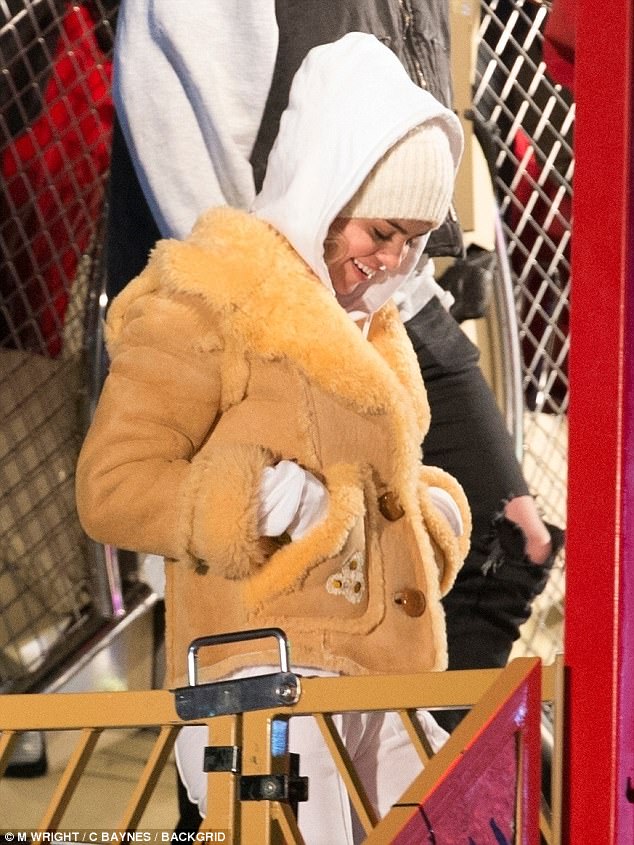 Smiles: Selena spent some time away from her on-again beau  while laughing it up with friends at Winter Wonderland in London on Saturday