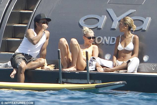 Bikini babes: The VS Angel highlighted her lithe frame in her vintage-inspired one-piece as she lay strewn across the back deck of the enviable boat alongside her bikini-wearing pal