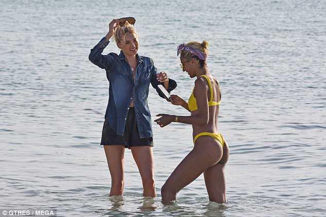 Denim days: Elsa donned an oversized denim shirt alongside her bikini-wearing pal