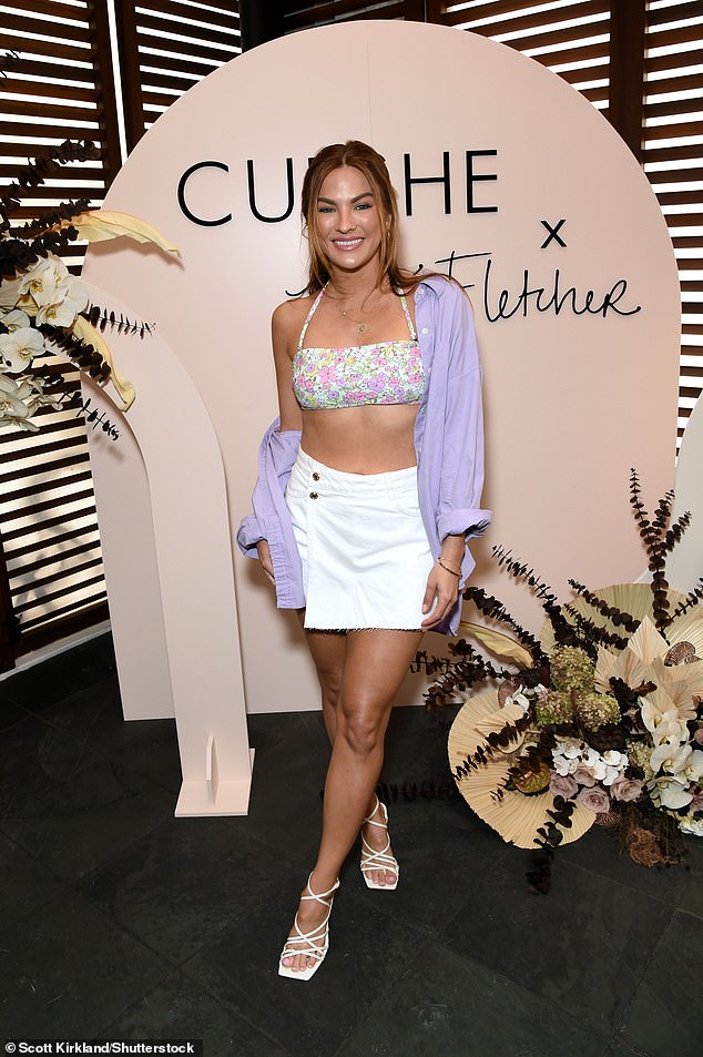 Summer ready: She paired the look with a white skirt that showcased her endless legs, and accessorized with a woven basket purse and purple shirt