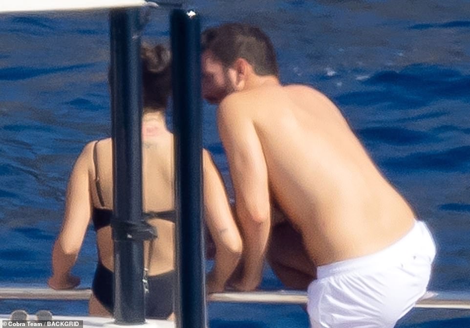 Very close: Andrea was seen leaning in to speak to Selena as he appeared to be climbing over the side of the yacht to jump in the sea