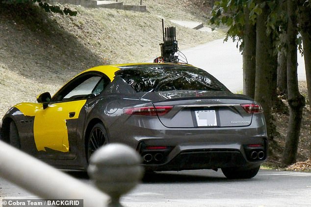 Going for a spin: The sportsman was joined by a flurry of crew members as he hopped into the charcoal car with canary yellow detailing