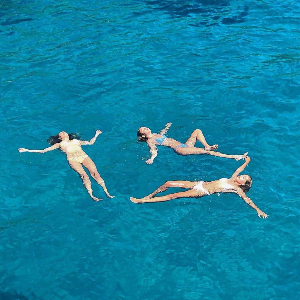 Sophia, Sistine, and Scarlet Stallone swimming in the middle of the ocean.