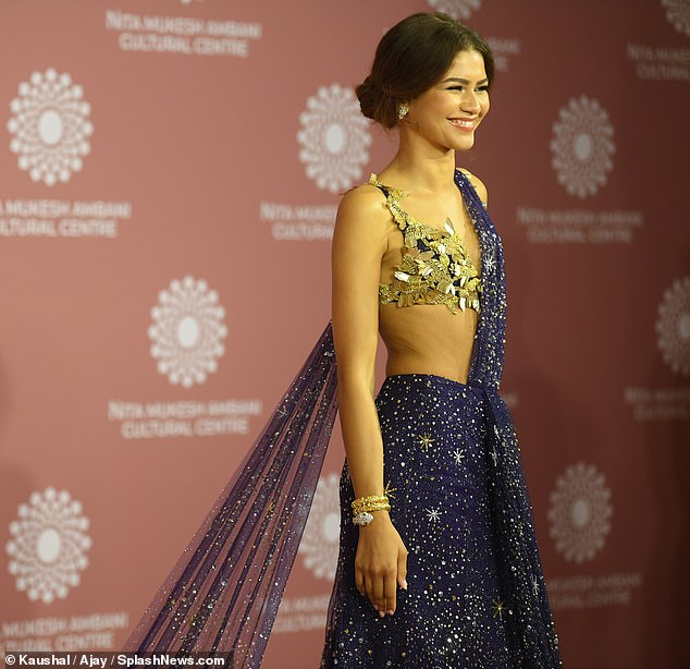 Wow! Her statement gown boasted a blue bra adorned with beaded gold birds and a dramatic sheer train and skirt featuring colourful floral designs around the hem