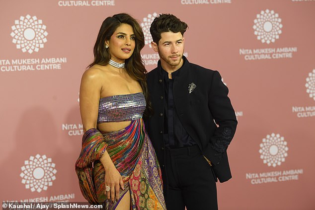 Eye-catching: The actress, 40, made sure to capture attention in a very extravagant ensemble as she posed arm-in-arm with her husband Nick, 30