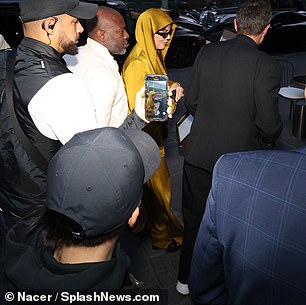 Eye-catching: She put on a fashionable display wearing a pair of loose-fitting, mustard yellow trousers made of a comfortable satin material along with a matching hooded top