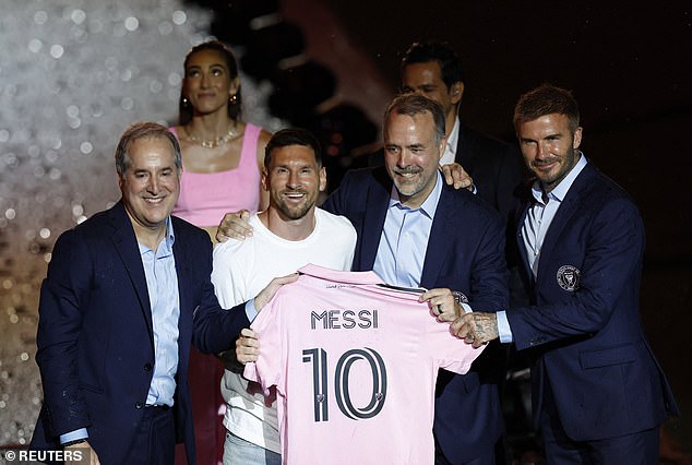 Inter Miami signing Lionel Messi poses with a club shirt with owners Jorge Mas, Jose R. Mas and David Beckham during the unveiling