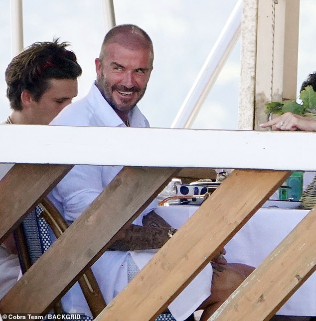 Casual: The designer enjoyed the meal on the restaurant's balcony with husband David (pictured), their daughter Harper, 12, and son Cruz, 18