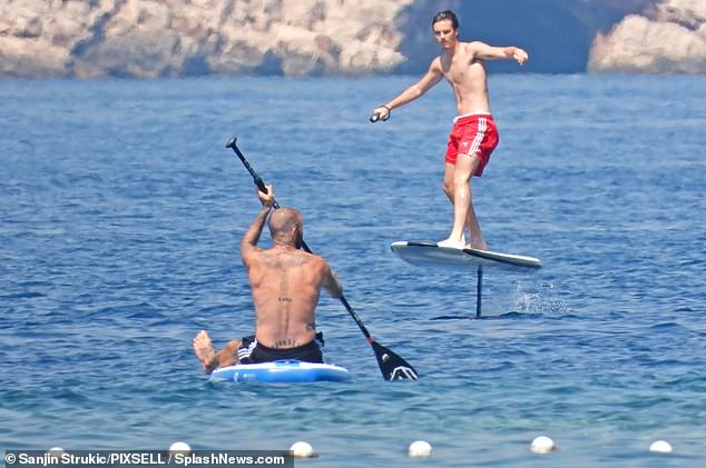 Zooming along! David cheered on his son Cruz, who sported red boardshorts, as he attempted to stay on his feet on a fliteboard