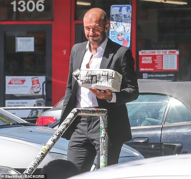 Jovial: David Beckham was in high spirits as he picked up lunch for his family at the Fat Sal's deli in Los Angeles on Thursday