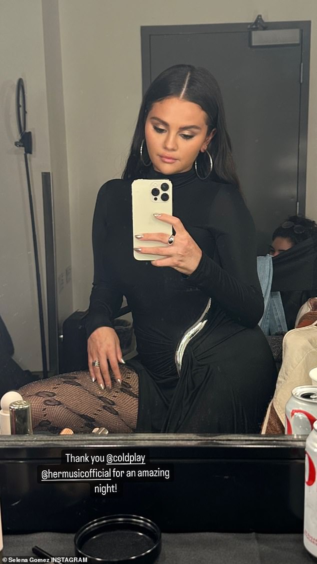 Back in black: Selena shared a photo of her slinky black dress and fishnet stockings in her dressing room while thanking Coldplay and H.E.R.