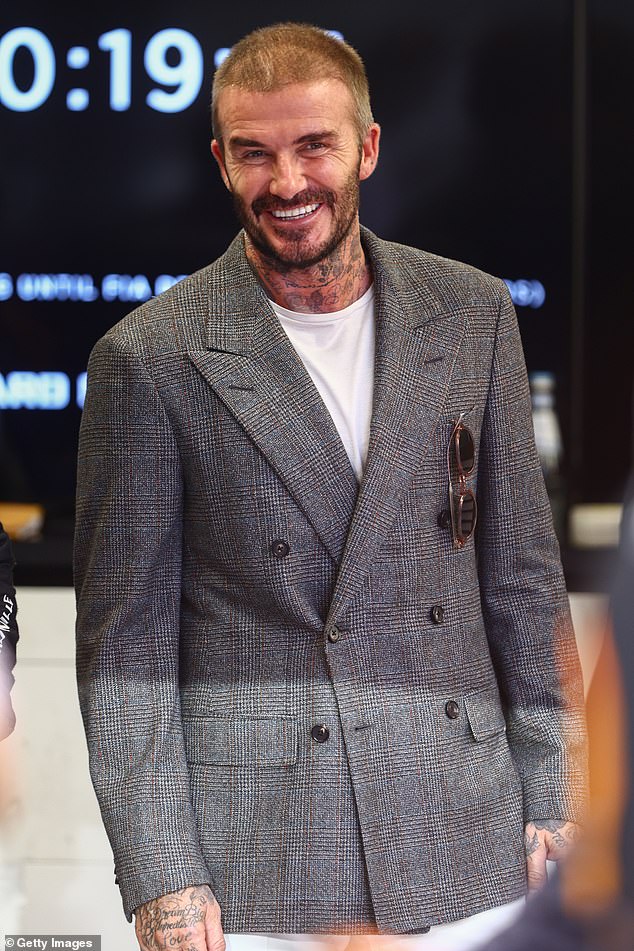 All smiles: The former footballer took some time out from his tour of the McLaren garage for the photo