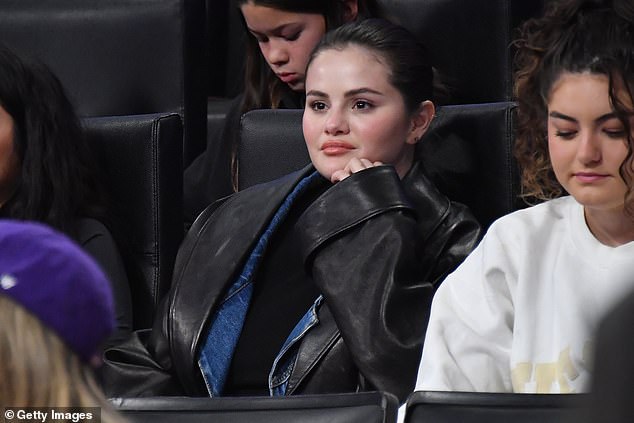 Hair back: She had her dark brown hair pulled back into a knot and accessorized with multiple earrings