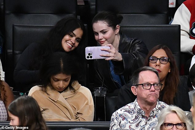 Family affair: Selena enjoyed the game with her cousin Priscilla Cosme