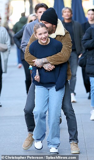 Harper cut a trendy figure in a navy ribbed jumper, which she wore with a pair of blue jeans and trainers, accessorising with gold hoop earrings