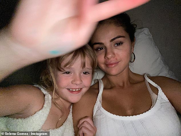 Selena Gomez shares a number of fun throwback snaps including a selfie with younger sister Gracie, 10, ahead of New Year's Eve: 'Moments in time'