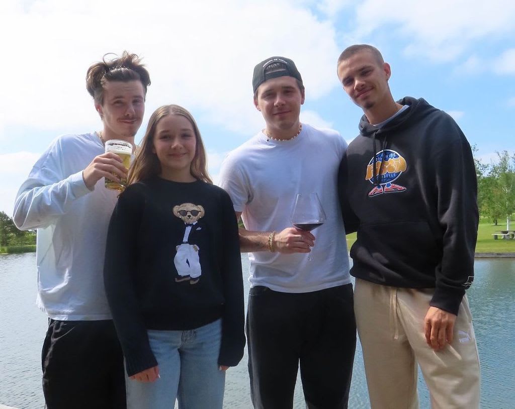 Cruz, Harper, Brooklyn and Romeo Beckham pose for a photograph in front of an outdoor lake