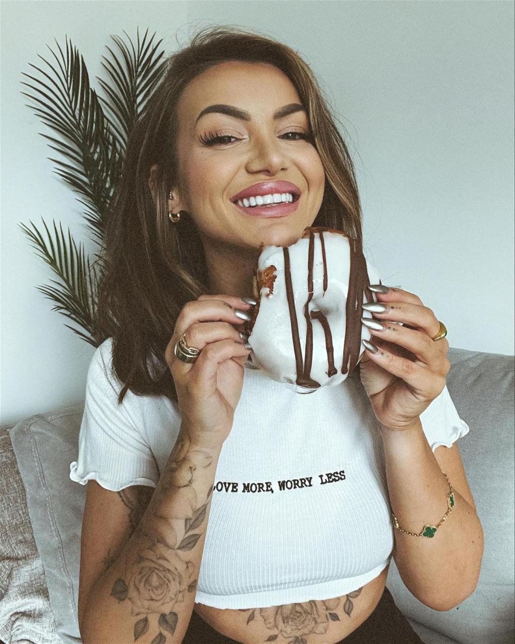 Abigail Rawlings poses with a donut in a white crop top