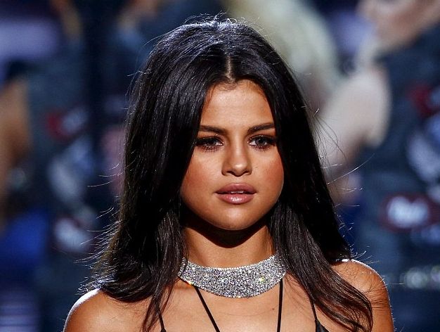 Selena Gomez goes braless in a slinky black gown with revealing slit as she performs at Victoria's Secret show