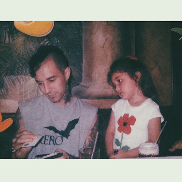 Little Atiana De La Hoya posing with step dad Travis Barker.