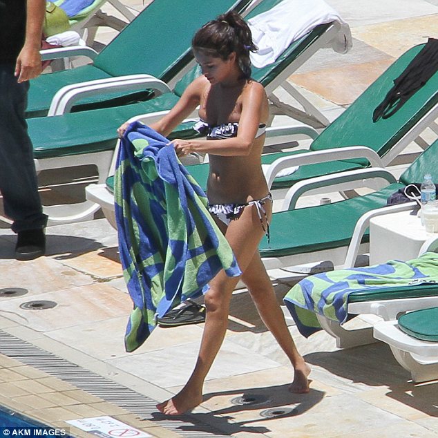 Topping up the tan: The 19-year-old singer was making the most of the sunshine over the weekend and was seen sunbathing by the pool at her hotel over the weekend