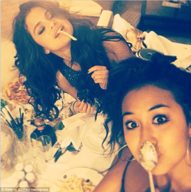 Selena Gomez looks girly as she chews on french fry... just days after vamping it up at magazine party