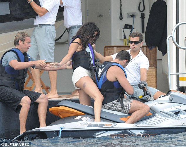 Helping hand: A crew member helped Selena (sporting a big bruise) onto the jetski