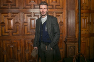 Image may contain David Beckham Clothing Apparel Coat Human Person Wood Suit Overcoat Jacket Pants and Furniture