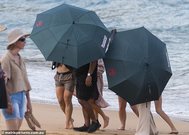 When the shoot was over, producers rushed to cloak the stars in towels, covering them from view behind a wall of Bunnings Warehouse umbrellas